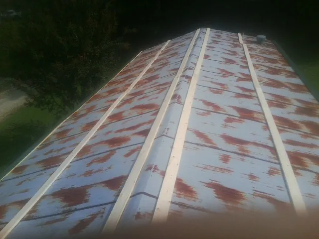 Rusted metal roof panels with new wood purlins before replacement — Storm Damage Roof Repair in Fort Edward by Roofing Brothers